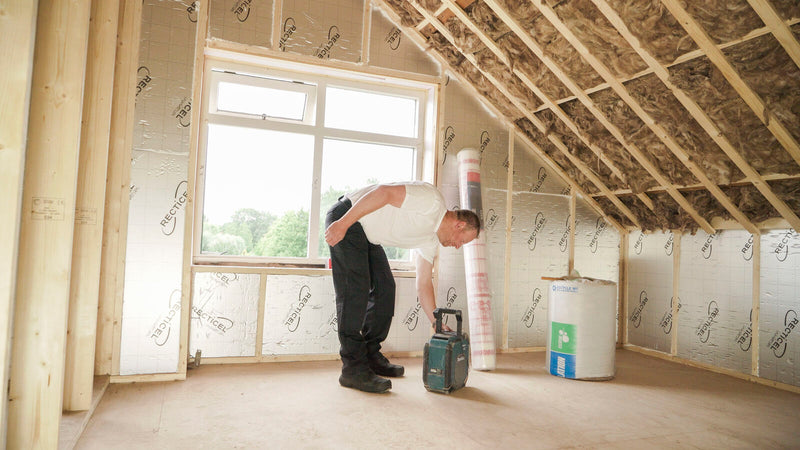 man op een zolder waar dakisolatie is toegepast