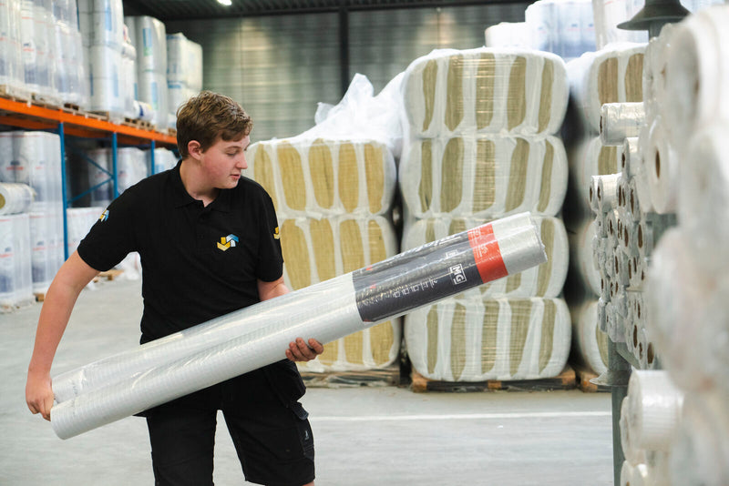 man houdt rol isolatiefolie vast