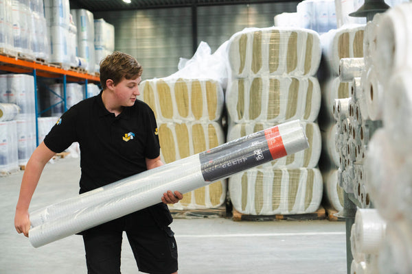 man houdt rol isolatiefolie vast